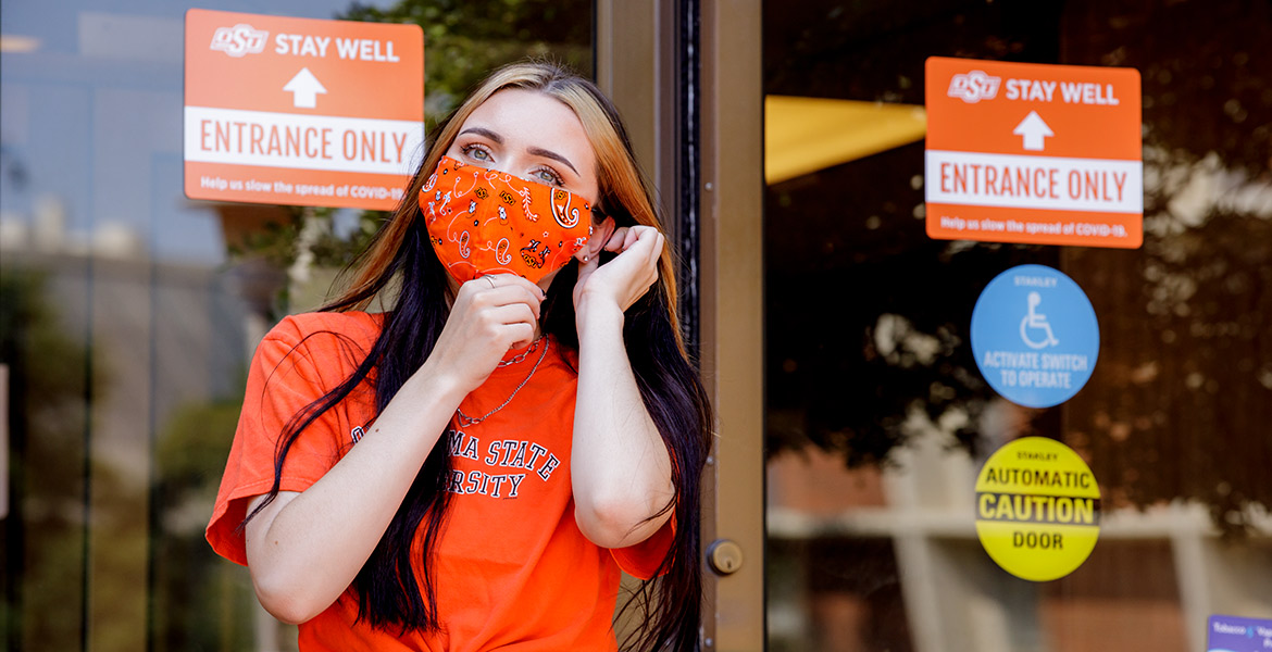 Student adjusts mask prior to entering Student Union