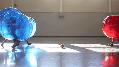 GIF of people in giant inflatable bubbles crashing into one another
