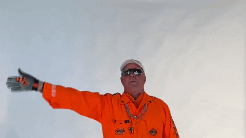 GIF of person in orange jumpsuit waving arm