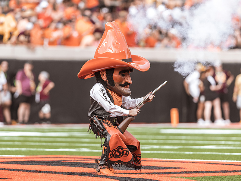 Pistol Pete firing the rifle at the football game