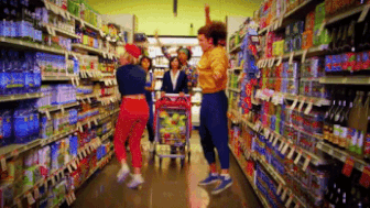 group of people dancing down a grocery story isle.